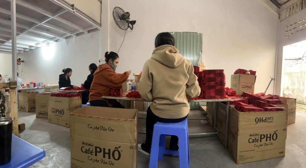 Nhân sự đang gia công dán túi giấy tại Bao Bì An Thịnh